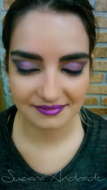 Maquiagem com sombra e batom roxos, olhos fechados